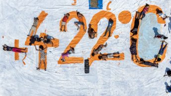 Deti ležiace na oranžovom nápise „42,2 °C“ namaľovanom na veľkom plátne.